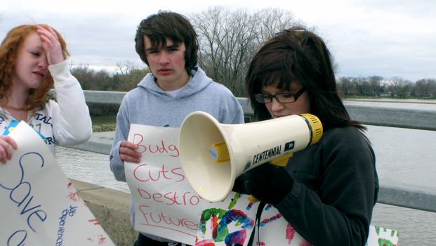 Brittney Harris and two fellow students protest on the Telegraph Bridge that goes over Elm St. 