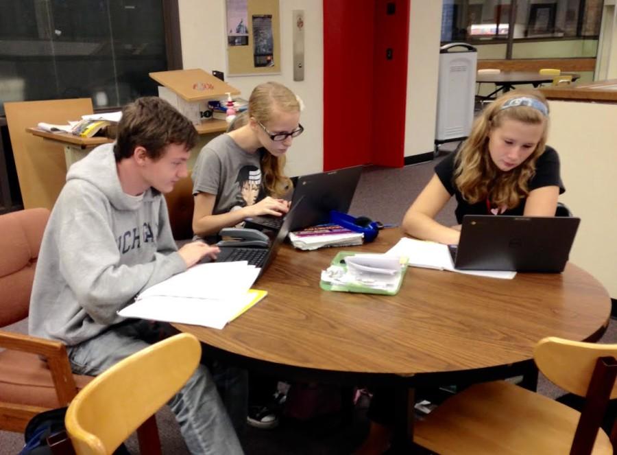 Three sophomores use chrome books in the Upper Learning Commons to work on assignments. The Learning Commons was the first location to receive the carts late this September, which replaced the old laptop ACERS. 
