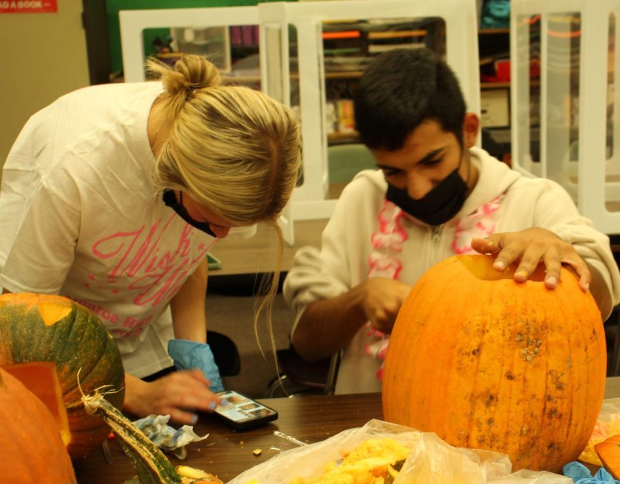 Sophomore Molly Meier and Junior Manuel Diaz carve their pumpkins. The two friends used each other as inspiration.